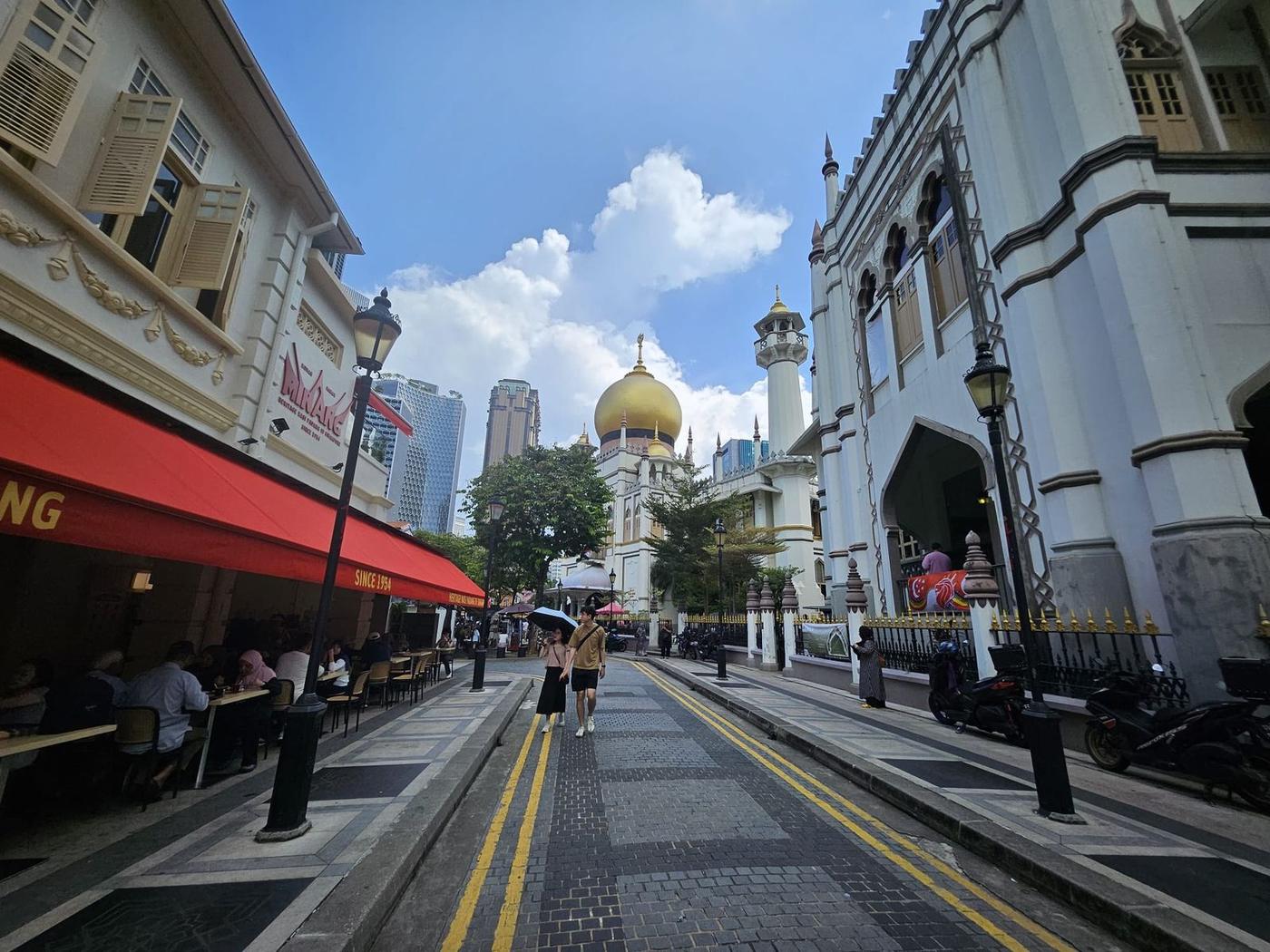Bussorah Street leading to Sultan Mosque, with heritage nasi padang restaurants under red awnings